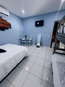 a bedroom with a bed and a table with a television at Lodge Ayla Punta Mango in Jucuarán
