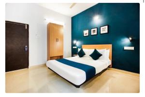 a bedroom with a large bed with a blue wall at Hotel Silverkey luxury Rooms in Hyderabad +2 photos