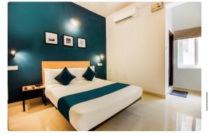 a bedroom with a large bed with a blue wall at Hotel Silverkey luxury Rooms in Hyderabad