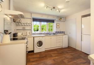 a kitchen with a washer and dryer at Jacobs Pond Monksilver in Stogumber