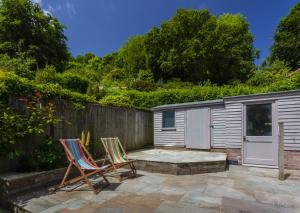two chairs sitting on a patio next to a fence at Jasmine Cottage Porlock in Porlock