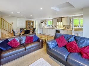 a living room with two leather couches and a kitchen at Bridlecott Monksilver in Monksilver