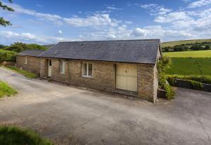 a brick house with a garage on a road at Hillway Lodge Withypool in Withypool