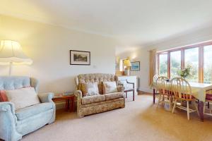 a living room with a couch and a table and chairs at Hillway Lodge Withypool in Withypool