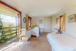 a bedroom with two beds and a window at Hillway Lodge Withypool in Withypool