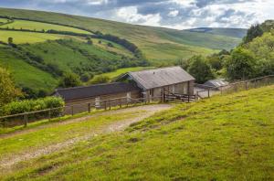 a barn on the side of a grassy hill at Hillway Lodge Withypool in Withypool +33 photos