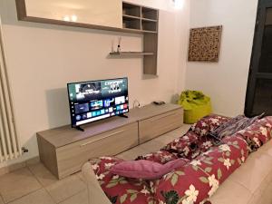 a living room with a couch and a flat screen tv at Casa Maddalena in Monteriggioni