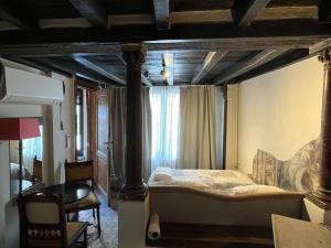 a bedroom with a canopy bed with a window at Het Kathedraalhuis Goudblomme in Antwerp