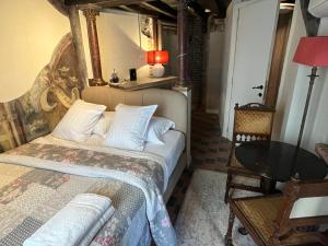 a bedroom with a bed and a table at Het Kathedraalhuis Goudblomme in Antwerp