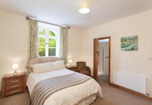 a bedroom with a bed and a window at The Mill House Bampton in Bampton