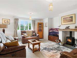 a living room with a couch and a fireplace at Meadow View Brushford in Dulverton