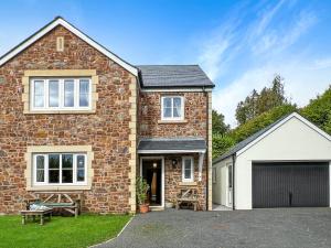 an image of a brick house with a garage at Meadow View Brushford in Dulverton