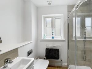 a white bathroom with a sink and a shower at Meadow View Brushford in Dulverton +6 photos