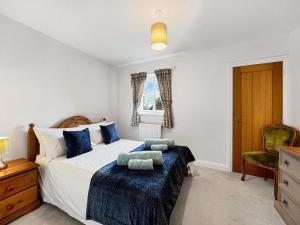 a bedroom with a bed and a chair at Meadow View Brushford in Dulverton