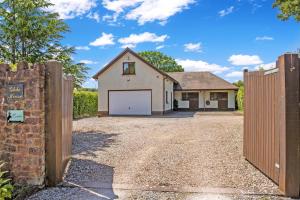a house with a gate and a garage at Dunkery View Wootton Courtenay in Minehead +8 photos