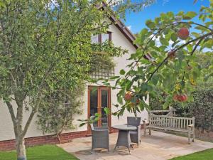 a house with a bench and an apple tree at Dunkery View Wootton Courtenay in Minehead