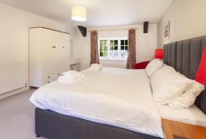 a bedroom with a large white bed and a window at Luccombe Cottage Luccombe in Luccombe