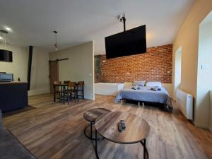 a bedroom with a bed and a brick wall at Spa d'Assier in Feurs