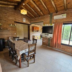 a dining room with a table and chairs and a television at Cabaña Mica in Nono