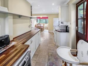a kitchen with white cabinets and a counter top at Merrijig Dulverton in Dulverton
