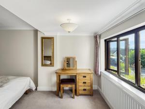 a bedroom with a bed and a desk with a television at Merrijig Dulverton in Dulverton