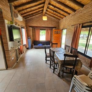 a living room with a table and chairs and a television at Cabaña Mica in Nono