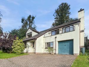 a large white house with a blue garage at Merrijig Dulverton in Dulverton