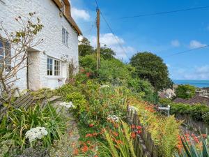 a cottage with a garden and flowers in front of it at The Crows Nest Porlock Weir in Porlock