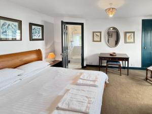 a bedroom with a bed and a table and a mirror at The Crows Nest Porlock Weir in Porlock