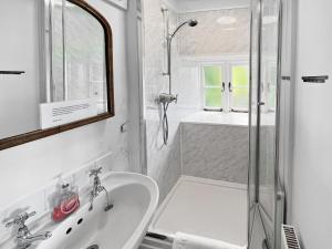 a white bathroom with a shower and a sink at The Crows Nest Porlock Weir in Porlock +41 photos