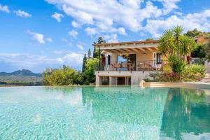 a villa with a swimming pool in front of a house at Villa Zeffiro in Arzachena