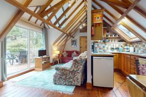 a kitchen and a living room with a couch at Little Hanger Porlock in Porlock