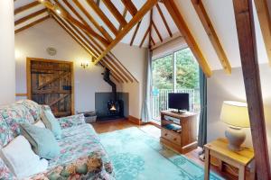 a living room with a couch and a tv at Little Hanger Porlock in Porlock