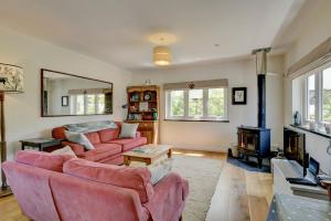 a living room with two couches and a fireplace at Linhay Cottage Withypool in Withypool