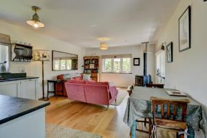a living room with a red couch and a table at Linhay Cottage Withypool in Withypool
