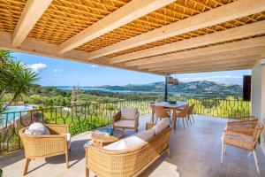 a patio with a couch and chairs and a table at Villa Zeffiro in Arzachena