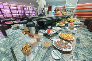 a buffet of food on a table in a restaurant at Hotel Golden Park Campinas Cambuí By Nacional Inn in Campinas