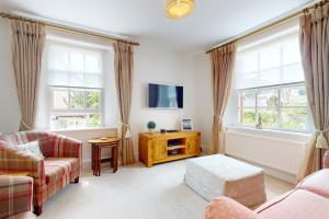 a living room with a couch and a tv at Bowness Porlock in Porlock