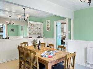 a dining room with a wooden table and chairs at Seagulls Rest Minehead in Minehead