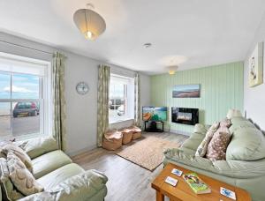a living room with two couches and a tv at Seagulls Rest Minehead in Minehead