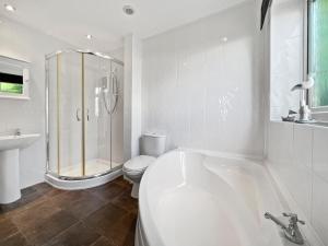 a white bathroom with a tub and a toilet at Seagulls Rest Minehead in Minehead +21 photos