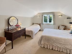 a bedroom with two beds and a mirror and a dresser at Forge Cottage Wootton Courtenay in Minehead