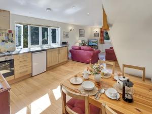 a kitchen and living room with a table and a dining room at Forge Cottage Wootton Courtenay in Minehead