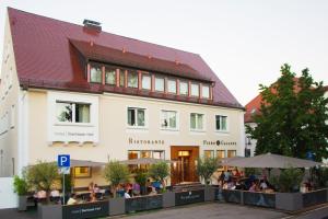 un edificio con gente sentada fuera de él en Illertisser Hof, en Illertissen