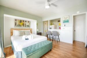 a bedroom with a large white bed with a blue bench at Oceanfront Condo, Private Patio, Beach Access, Sunset Views in Carlsbad