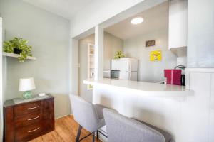 a kitchen with a counter with chairs and a refrigerator at Oceanfront Condo, Private Patio, Beach Access, Sunset Views in Carlsbad