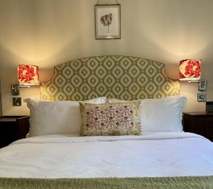a bedroom with a large white bed with two lamps at The Old Kitchen Exford in Exford