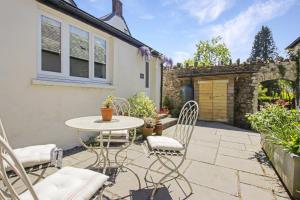 a patio with a table and chairs in front of a house at The Old Kitchen Exford in Exford