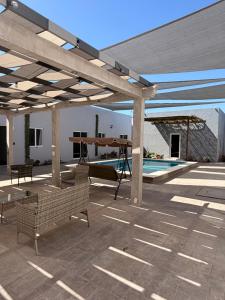 a pavilion with a swing and a swimming pool at Los Agaves Lto in Loreto