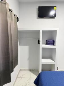 a bedroom with a tv on the wall and a bed at Los Agaves Lto in Loreto